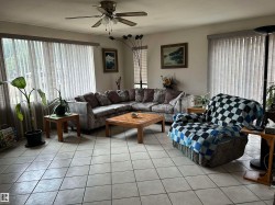 Living area featuring light tile patterned floors, ceiling fan, and a textured ceiling - 