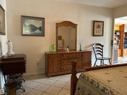 Bedroom with light tile patterned floors and baseboards - 
