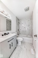 Bathroom featuring vanity,  shower combination, and light marble finish flooring - 