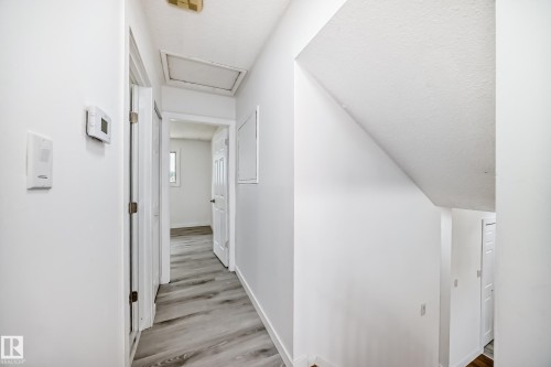 Hallway with attic access, light wood-style flooring, and a textured ceiling - 13116 31 Strret, Edmonton, AB - Indoor Photo Showing Other Room
