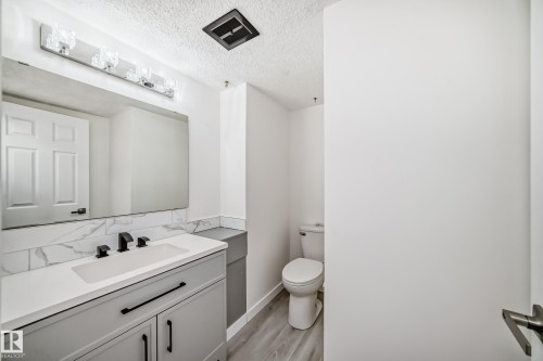 Bathroom featuring vanity, a textured ceiling, and light wood-style flooring - 13116 31 Strret, Edmonton, AB - Indoor Photo Showing Bathroom