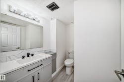 Bathroom featuring vanity, a textured ceiling, and light wood-style flooring - 