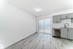 Kitchen featuring gray cabinets, decorative backsplash, dishwasher, and light wood-style flooring - 