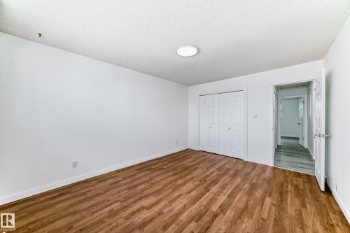 Unfurnished bedroom featuring wood finished floors, a textured ceiling, and a closet - 13116 31 Strret, Edmonton, AB - Indoor Photo Showing Other Room
