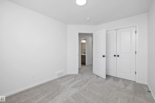 Unfurnished bedroom featuring light carpet and a closet - 5458 Hawthorn Run, Edmonton, AB - Indoor Photo Showing Other Room