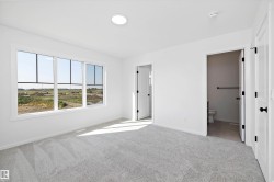Unfurnished bedroom featuring light carpet and ensuite bathroom - 
