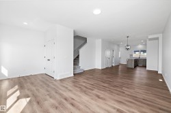 Unfurnished living room with recessed lighting, a chandelier, dark wood finished floors, and stairway - 