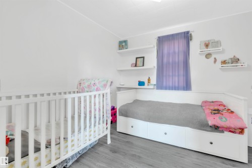 Bedroom featuring a nursery area and wood finished floors - 4702 50 Avenue, Cold Lake, AB - Indoor Photo Showing Bedroom