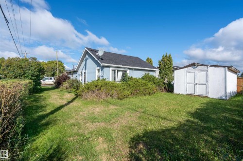 View of grassy yard featuring a storage unit - 4702 50 Avenue, Cold Lake, AB - Outdoor