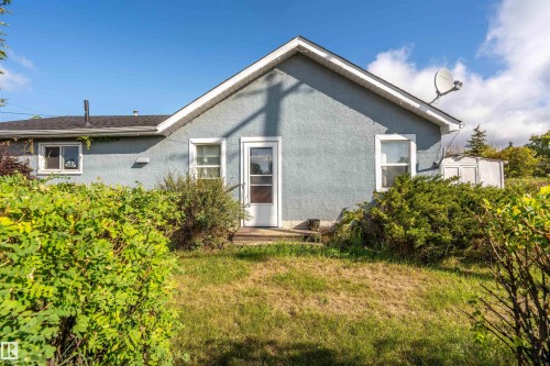 Rear view of property featuring a yard and stucco siding - 4702 50 Avenue, Cold Lake, AB - Outdoor