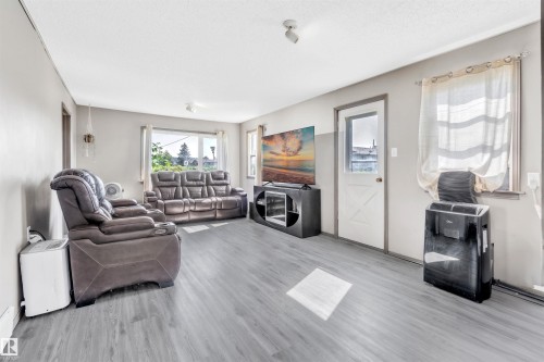 Living room featuring wood finished floors and baseboards - 4702 50 Avenue, Cold Lake, AB - Indoor Photo Showing Other Room