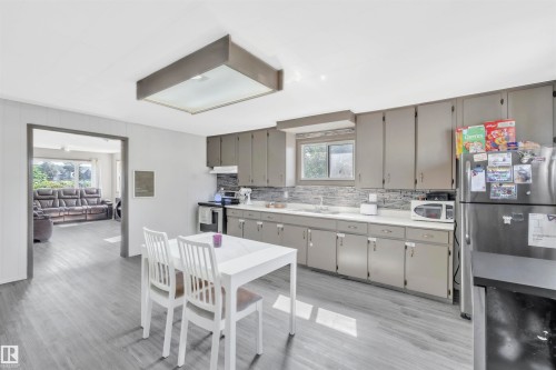 Kitchen featuring gray cabinetry, light countertops, appliances with stainless steel finishes, and light wood finished floors - 4702 50 Avenue, Cold Lake, AB - Indoor