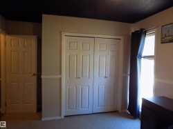 Unfurnished bedroom featuring light carpet, a closet, and a textured ceiling - 