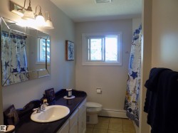 Bathroom featuring light tile patterned flooring, vanity, baseboard heating, and curtained shower - 