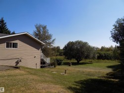 View of grassy yard with stairway and a deck - 
