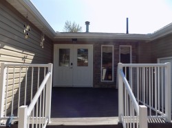 Doorway to property featuring a deck and stone siding - 