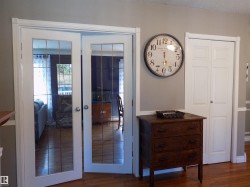 Doorway with wood finished floors, french doors, and a textured ceiling - 