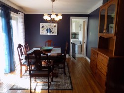 Dining room with dark wood finished floors, a chandelier, and ornamental molding - 