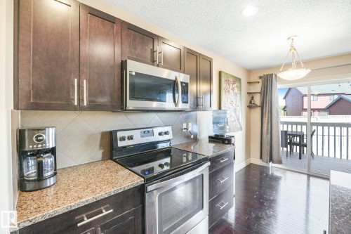 Kitchen with appliances with stainless steel finishes, dark brown cabinetry, tasteful backsplash, pendant lighting, and a textured ceiling - 6819 Cardinal Link, Edmonton, AB - Indoor Photo Showing Kitchen