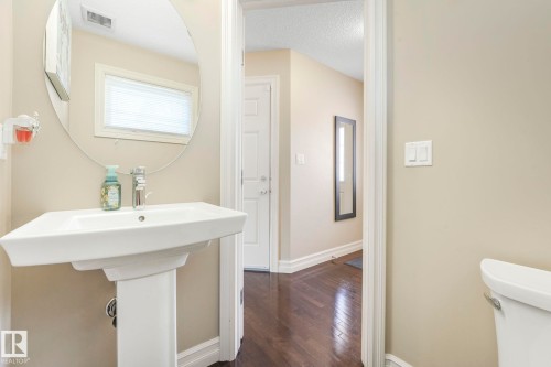 Half bathroom with dark wood-type flooring and a textured ceiling - 6819 Cardinal Link, Edmonton, AB - Indoor Photo Showing Bathroom