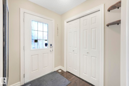 Doorway to outside with a textured ceiling and wood finished floors - 6819 Cardinal Link, Edmonton, AB - Indoor Photo Showing Other Room