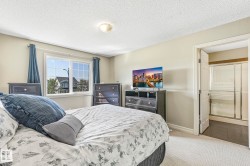Carpeted bedroom featuring a textured ceiling and baseboards - 