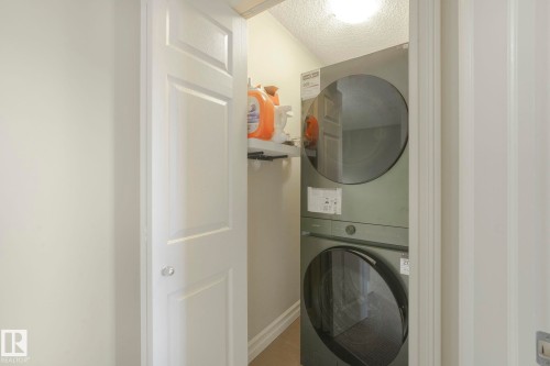 Washroom featuring stacked washer / dryer and a textured ceiling - 6819 Cardinal Link, Edmonton, AB - Indoor Photo Showing Laundry Room