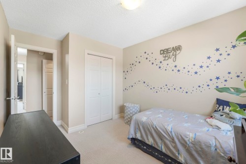 Bedroom with light colored carpet, a textured ceiling, and a closet - 6819 Cardinal Link, Edmonton, AB - Indoor Photo Showing Bedroom