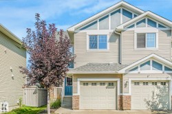 Craftsman-style home with a garage, a shingled roof, concrete driveway, and stone siding - 