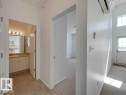 Hallway featuring a wall unit AC and light colored carpet - Edmonton, AB  - Indoor Photo Showing Other Room 