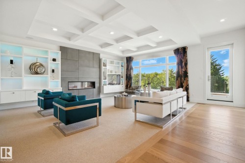 Living room with a tile fireplace, coffered ceiling, recessed lighting, light engineered hardwood flooring - 11823 Saskatchewan Drive, Edmonton, AB - Indoor