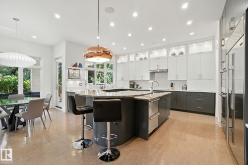 Kitchen with a large island, hanging light fixtures, a breakfast bar, recessed lighting, and white cabinetry - 11823 Saskatchewan Drive, Edmonton, AB - Indoor Photo Showing Kitchen With Upgraded Kitchen