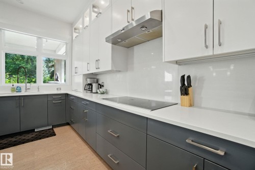 Kitchen featuring under cabinet range hood, white cabinets, gray cabinets, black electric cooktop, and glass insert cabinets - 11823 Saskatchewan Drive, Edmonton, AB - Indoor Photo Showing Kitchen With Upgraded Kitchen