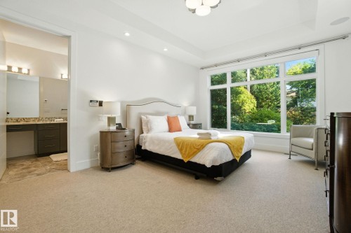 Bedroom featuring light carpet, a tray ceiling, recessed lighting, and connected bathroom - 11823 Saskatchewan Drive, Edmonton, AB - Indoor Photo Showing Bedroom