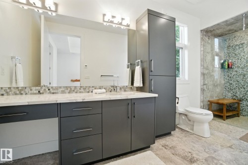 Bathroom with vanity, a tile shower, backsplash, and tile walls - 11823 Saskatchewan Drive, Edmonton, AB - Indoor Photo Showing Bathroom