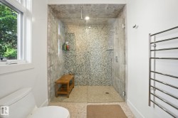 Full bath with plenty of natural light, a shower stall, and a towel warming rack - 