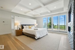 Bedroom with light wood finished floors, coffered ceiling, beam ceiling, and recessed lighting - 