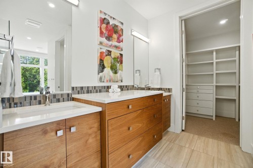 Full bath with recessed lighting, two vanities, decorative backsplash, a spacious closet, and light tile patterned flooring - 11823 Saskatchewan Drive, Edmonton, AB - Indoor Photo Showing Bathroom