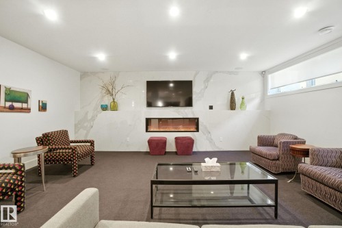 Living area featuring a premium fireplace, carpet floors, and recessed lighting - 11823 Saskatchewan Drive, Edmonton, AB - Indoor Photo Showing Living Room