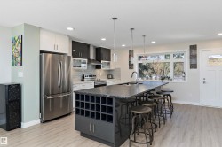 Kitchen with appliances with stainless steel finishes, decorative backsplash, a center island with sink, a kitchen breakfast bar, and pendant lighting - 