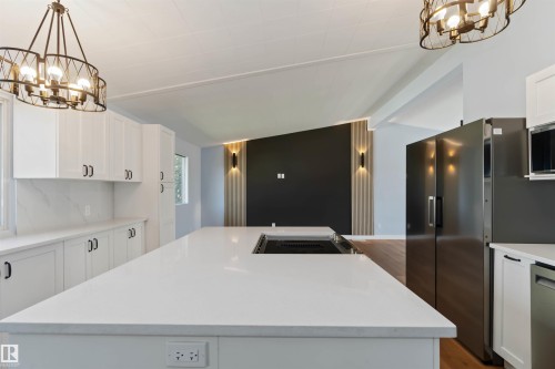 Kitchen featuring a chandelier, hanging light fixtures, white cabinets, and a center island - 6808 95 Avenue, Edmonton, AB - Indoor Photo Showing Kitchen