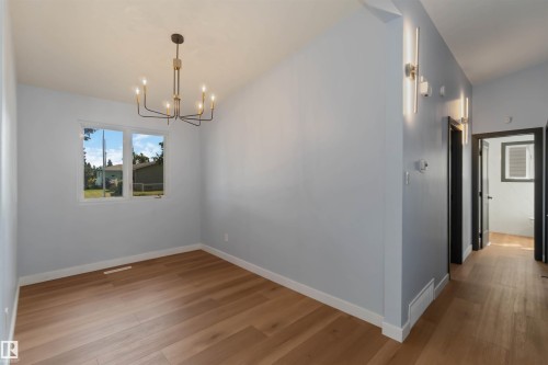 Unfurnished dining area featuring wood finished floors and a chandelier - 6808 95 Avenue, Edmonton, AB - Indoor Photo Showing Other Room