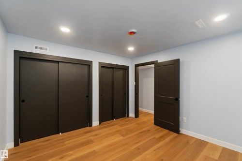Unfurnished bedroom featuring two closets, light wood-type flooring, and recessed lighting - 6808 95 Avenue, Edmonton, AB - Indoor Photo Showing Other Room