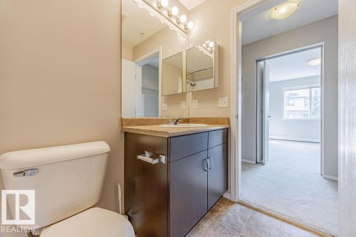 Half bath with vanity, a textured ceiling, and light tile patterned floors - Edmonton, AB - Indoor Photo Showing Bathroom