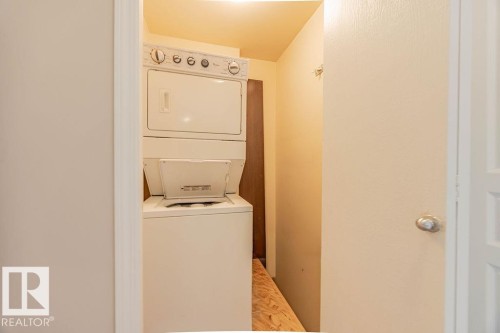 Washroom with stacked washer / drying machine - Edmonton, AB - Indoor Photo Showing Laundry Room