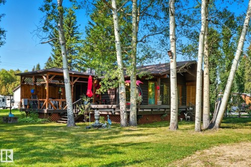 Rear view of house with a wooden deck and a yard - 6309 49 St, Rural Wetaskiwin County, AB - Outdoor With Deck Patio Veranda
