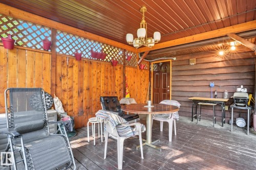 Wooden terrace featuring a grill and outdoor dining area - 6309 49 St, Rural Wetaskiwin County, AB - Outdoor With Deck Patio Veranda With Exterior