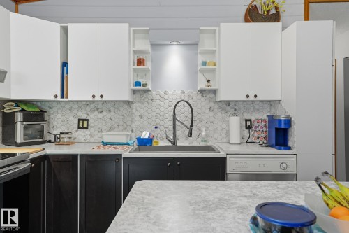 Kitchen featuring open shelves, white cabinets, light countertops, backsplash, and dishwasher - 6309 49 St, Rural Wetaskiwin County, AB - Indoor Photo Showing Kitchen With Upgraded Kitchen