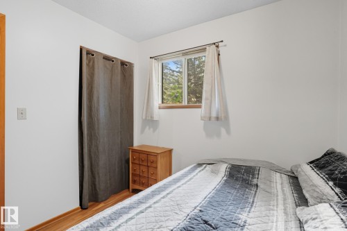 Bedroom with wood finished floors and baseboards - 6309 49 St, Rural Wetaskiwin County, AB - Indoor Photo Showing Bedroom