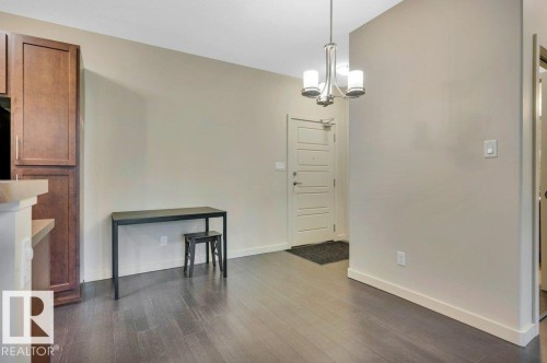 Unfurnished dining area with dark wood-type flooring and a chandelier - 140 308 Ambleside Link, Edmonton, AB - Indoor Photo Showing Other Room